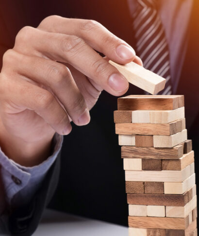 Planning, risk and strategy in business concept, businessman gam Planning, risk and strategy in business concept, businessman gambling placing wooden block on a tower.
