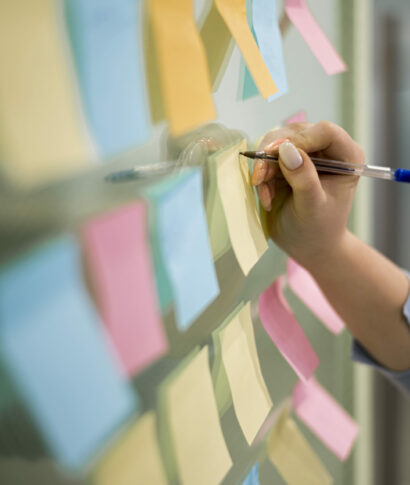 woman-writing-sticky-notes-office-window